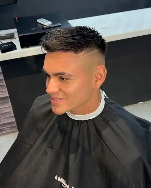 Cliente sonriendo con un fade recién terminado en el sillón