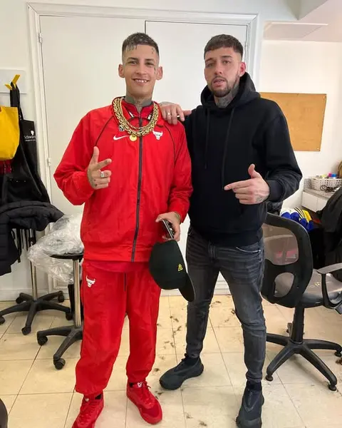 Barbero y cliente posando después del corte